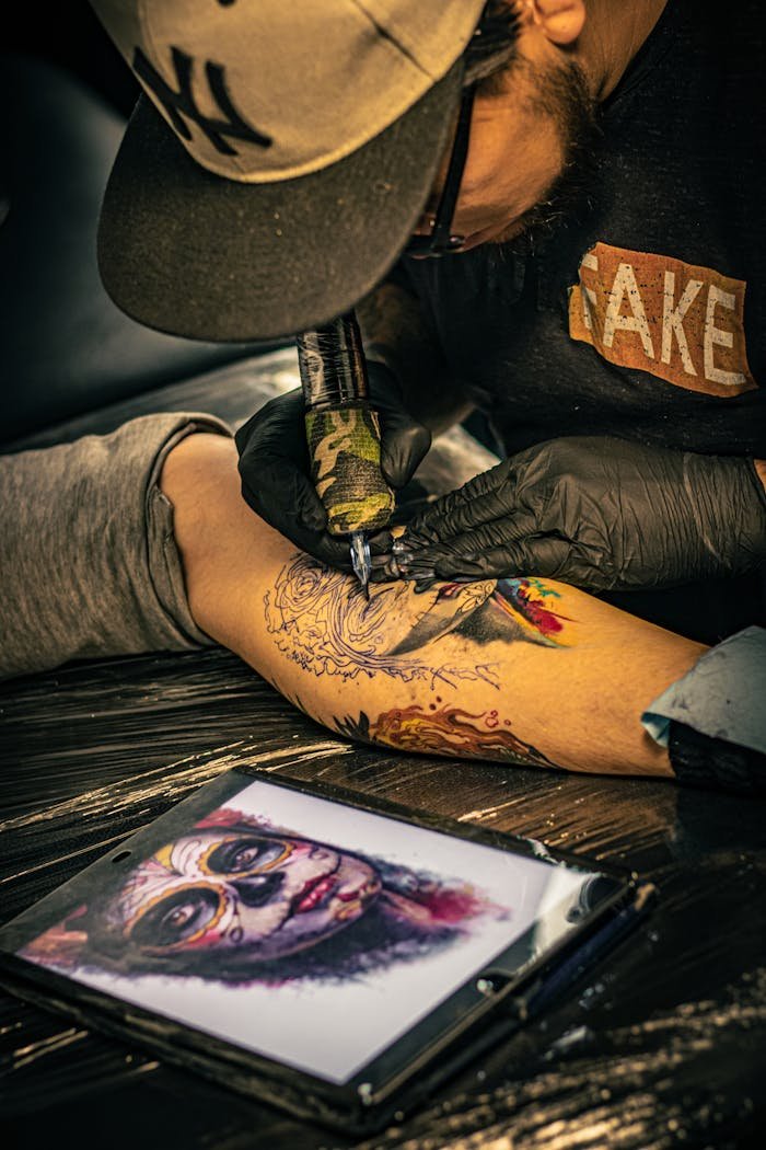Tattoo artist working on a detailed arm tattoo in a Ciudad de México studio.